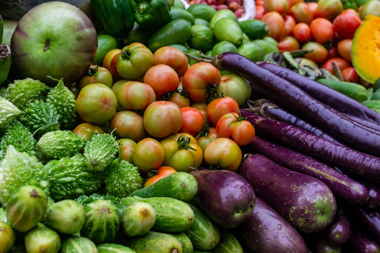 A vibrant assortment of fresh vegetables including tomatoes, cucumbers, and eggplants at a local market in Dhaka, Bangladesh.